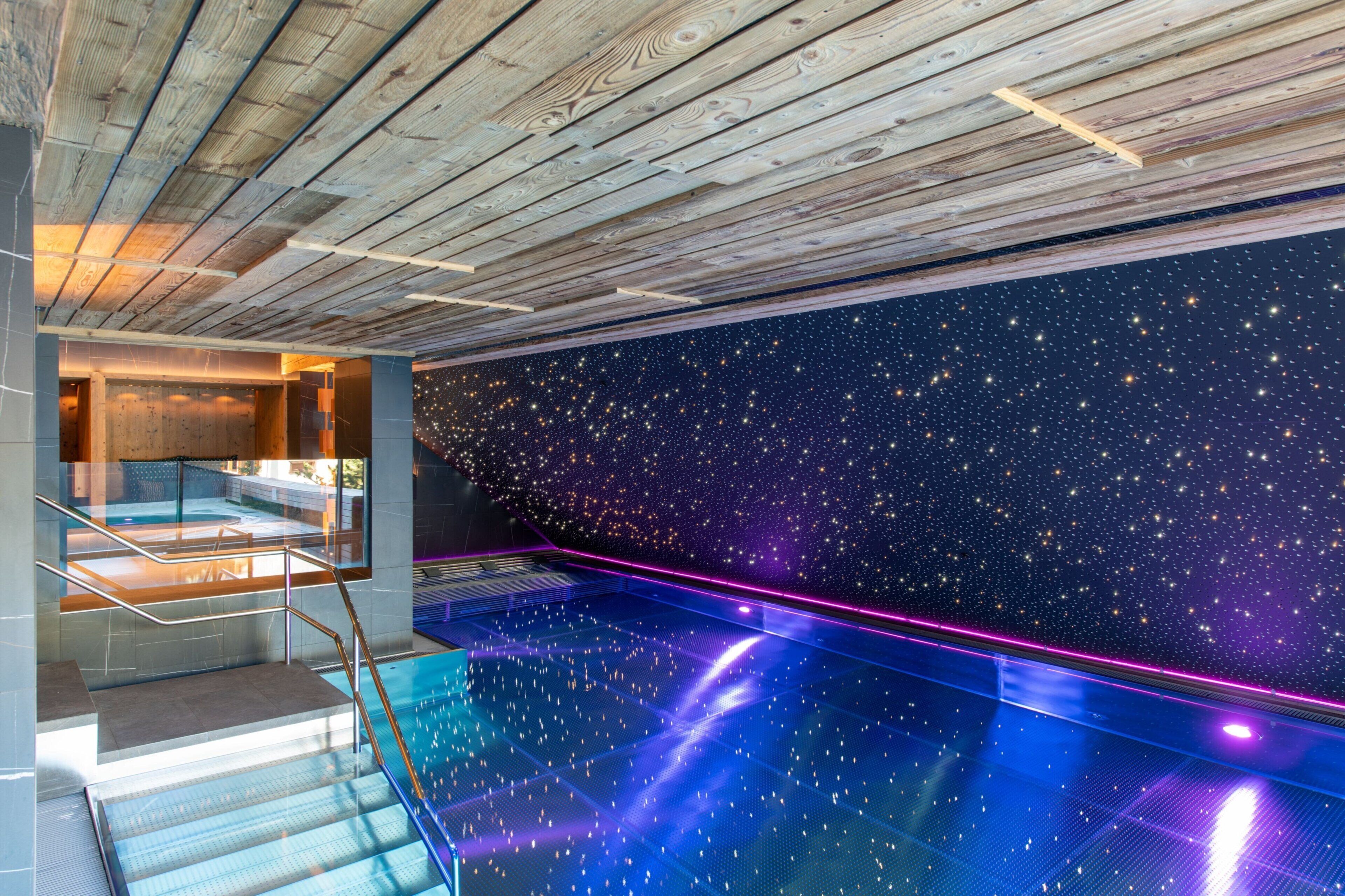 Una piscina cubierta, una piscina al aire libre, tumbonas