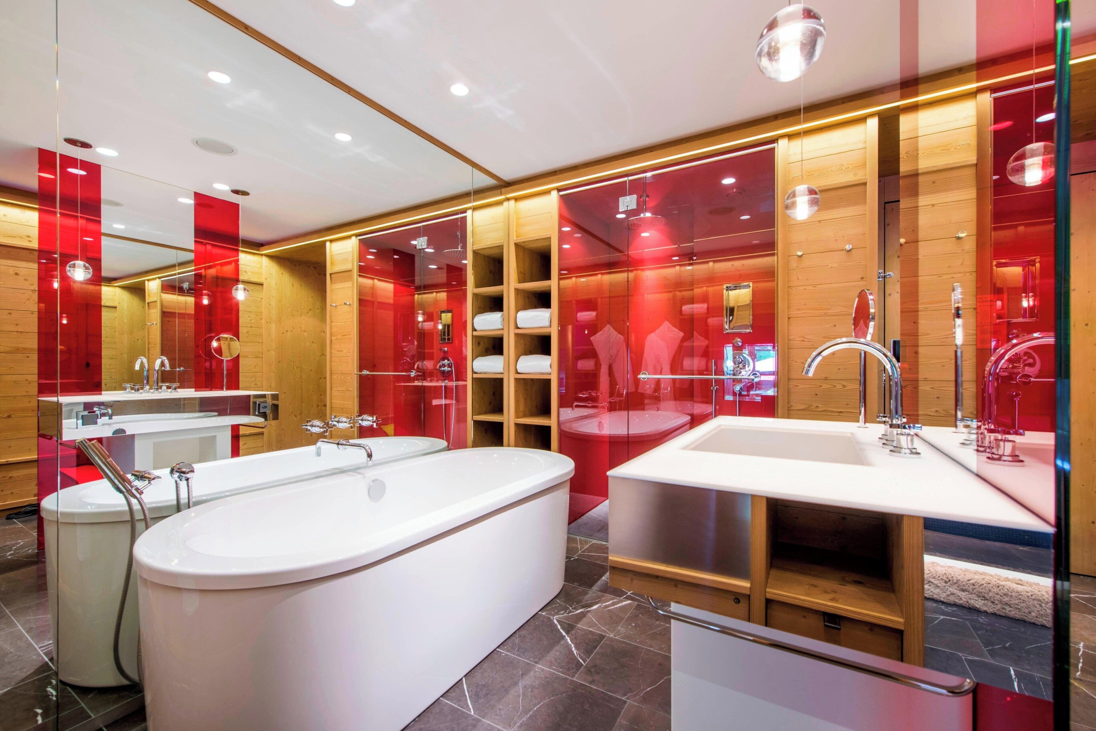 A modern bathroom with a large freestanding bathtub, a separate sink area, and a vanity with a mirror.