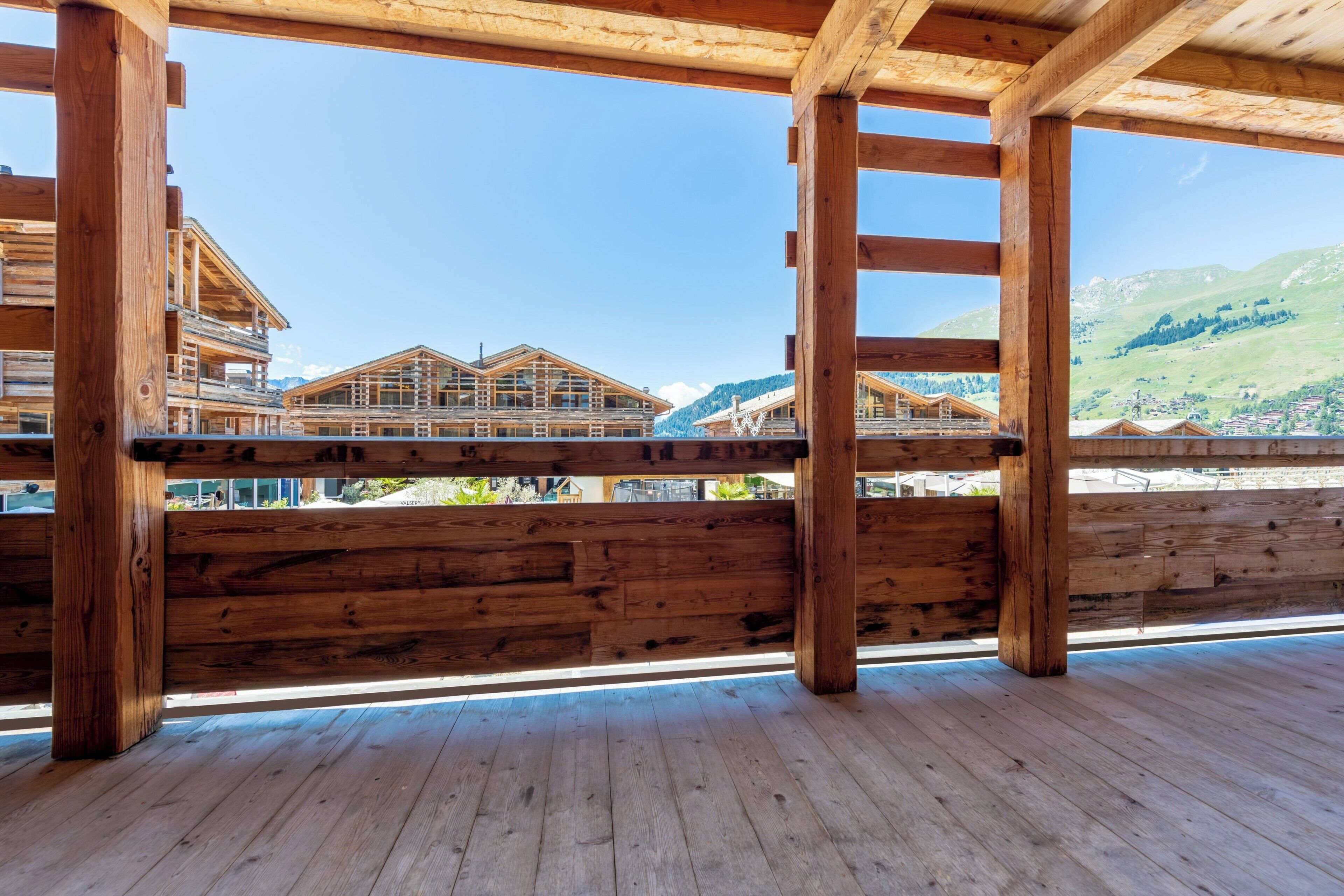 Eine Holzterrasse mit Blick auf Bergdörfer.