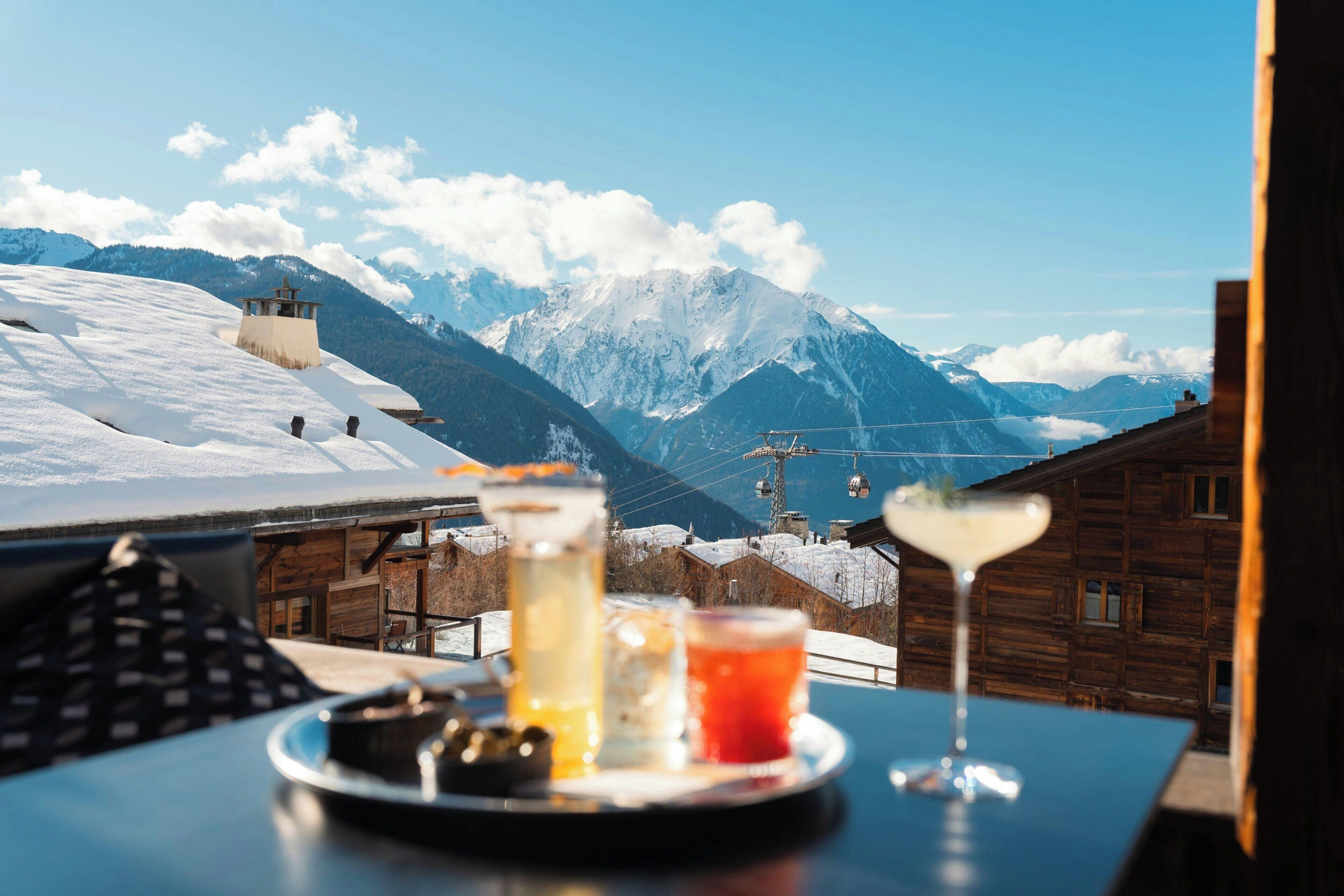 A table with drinks and a mountain view.