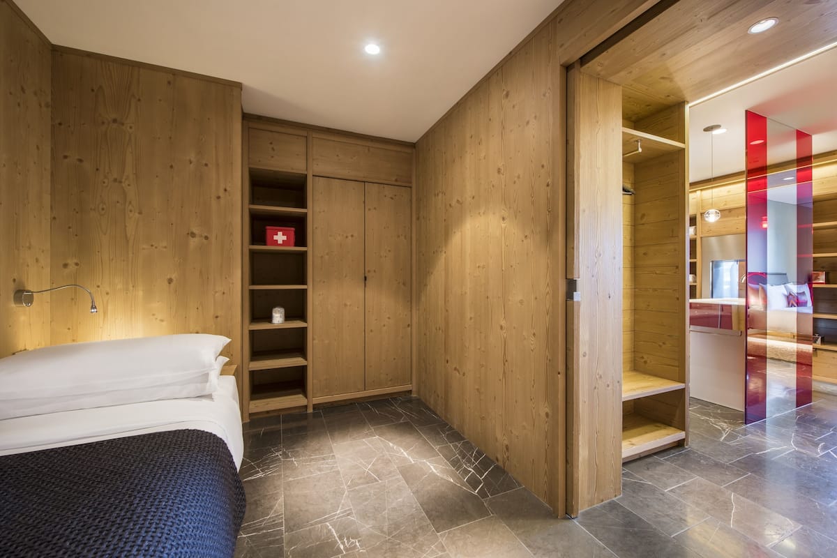 Un dormitorio con cama, armario de madera y estantería empotrada.