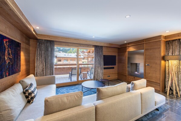 A modern living room with a large sofa, a small round table, and a fireplace.