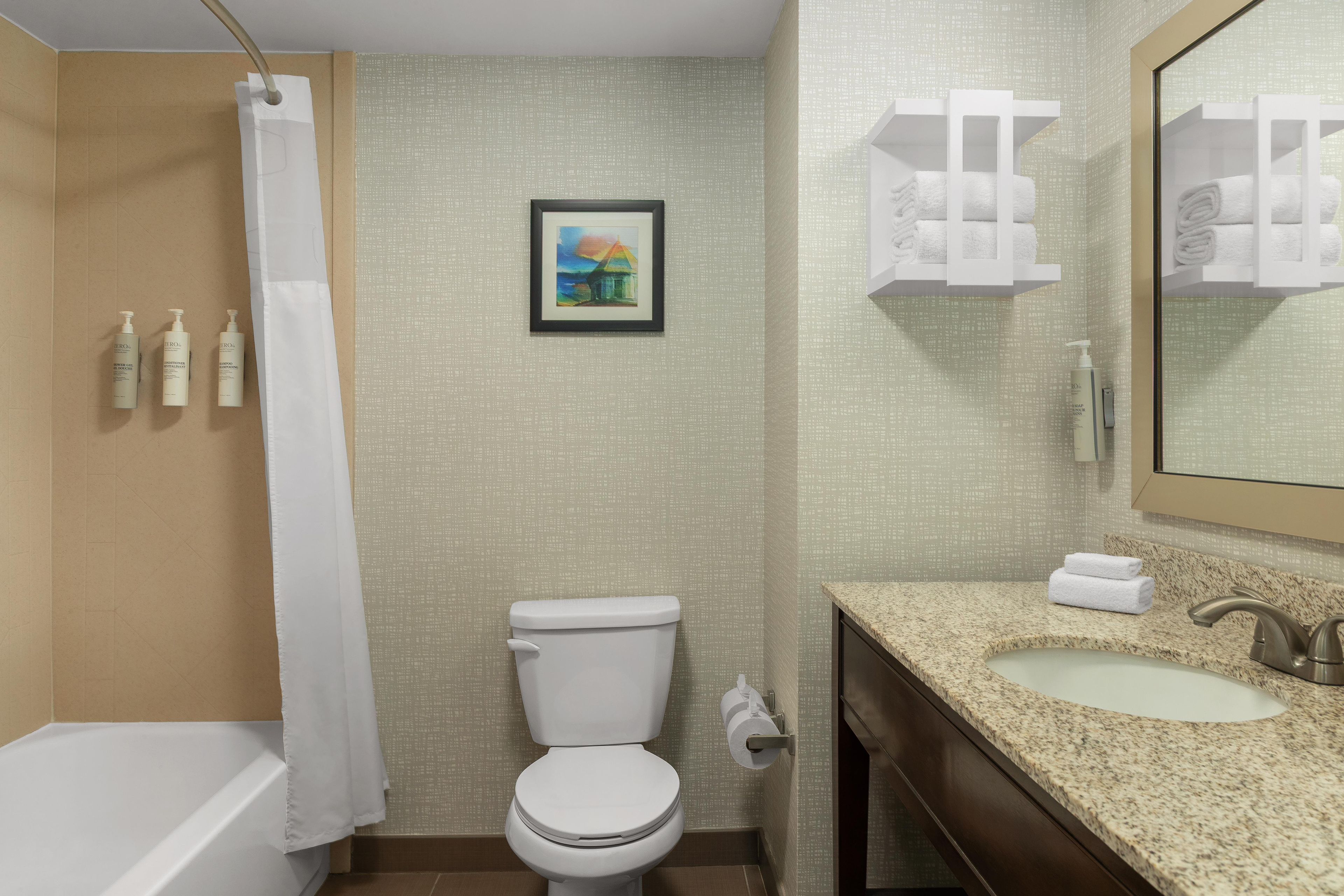 Une salle de bain équipée de toilettes, d’un lavabo et d’un rideau de douche.