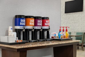Kaffestation med fire dispensere mærket mørkrist, lysrist, koffeinfri og varmt vand.