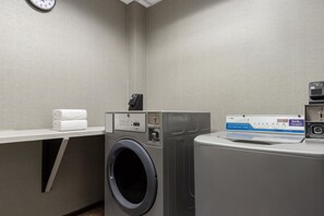 A laundry room with a washing machine, dryer, and a towel rack with folded towels. - Hampton Inn & Suites Adairsville-Calhoun Area (Adairsville)