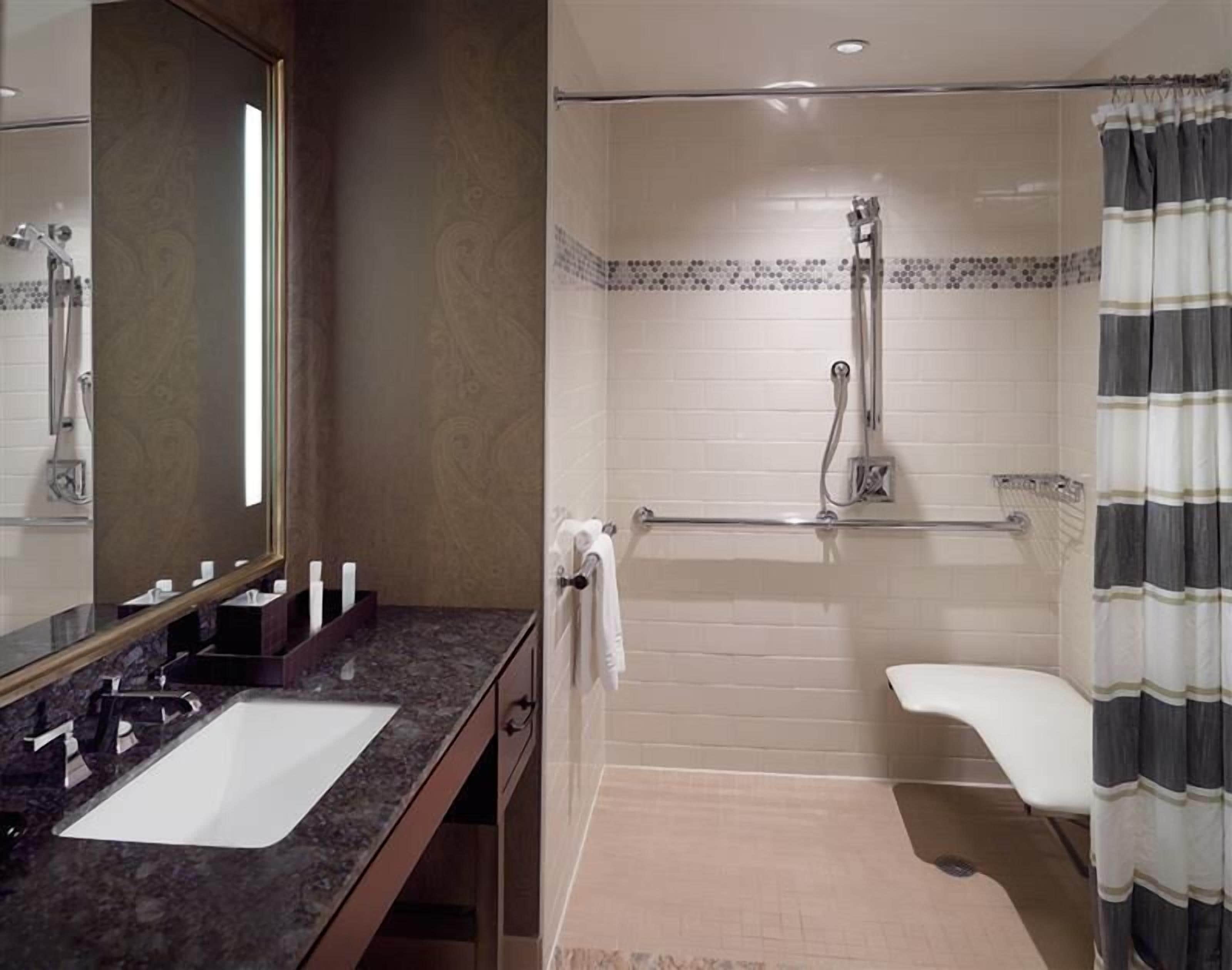 Une salle de bain avec un double lavabo, une douche et des toilettes.