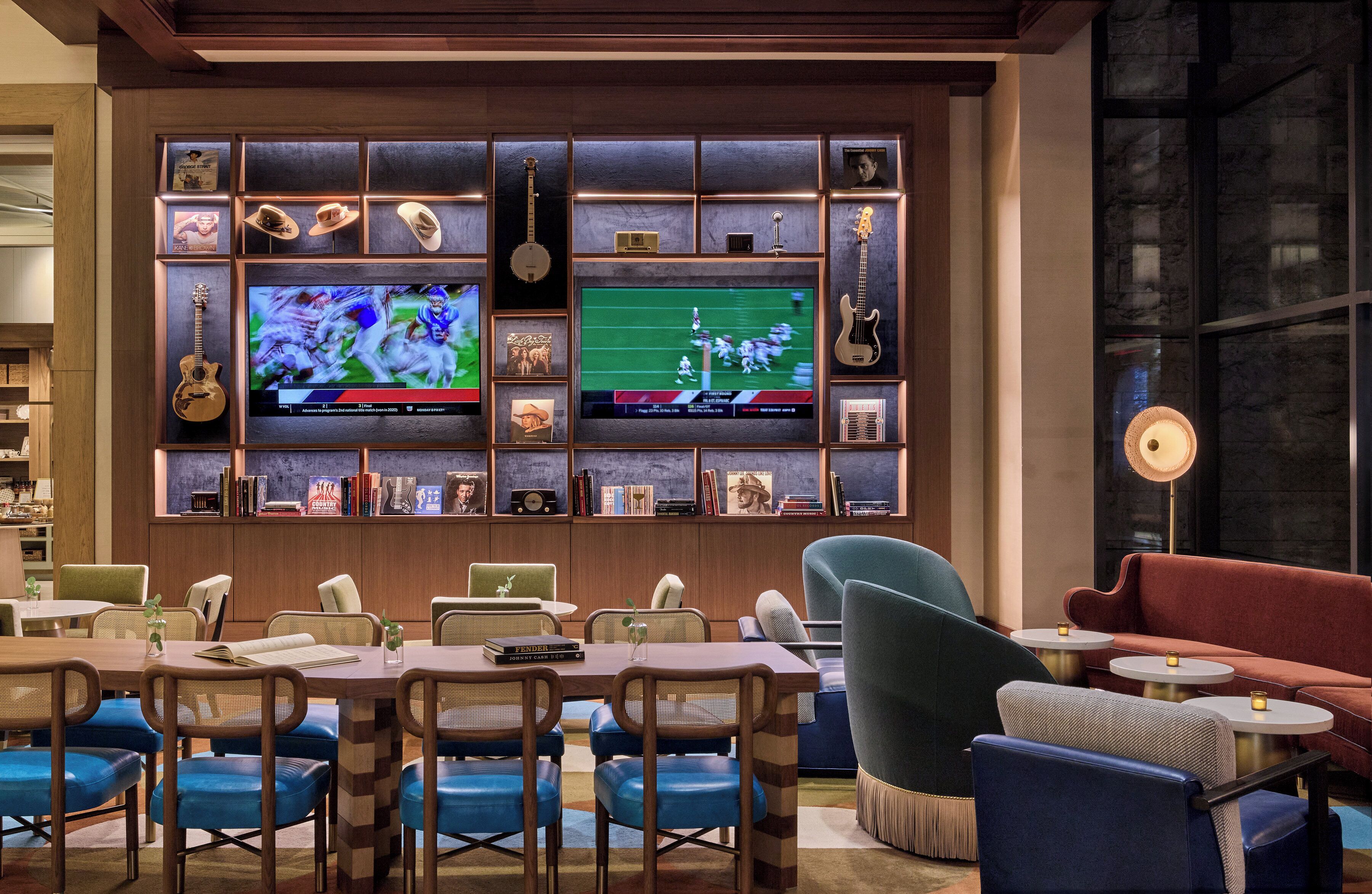 A modern lounge area with a television, shelves with memorabilia, and comfortable seating.