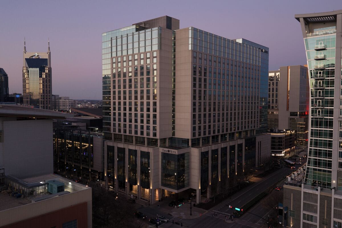 Een modern hotel met een glazen gevel, meerdere verdiepingen en een opvallende ingang.