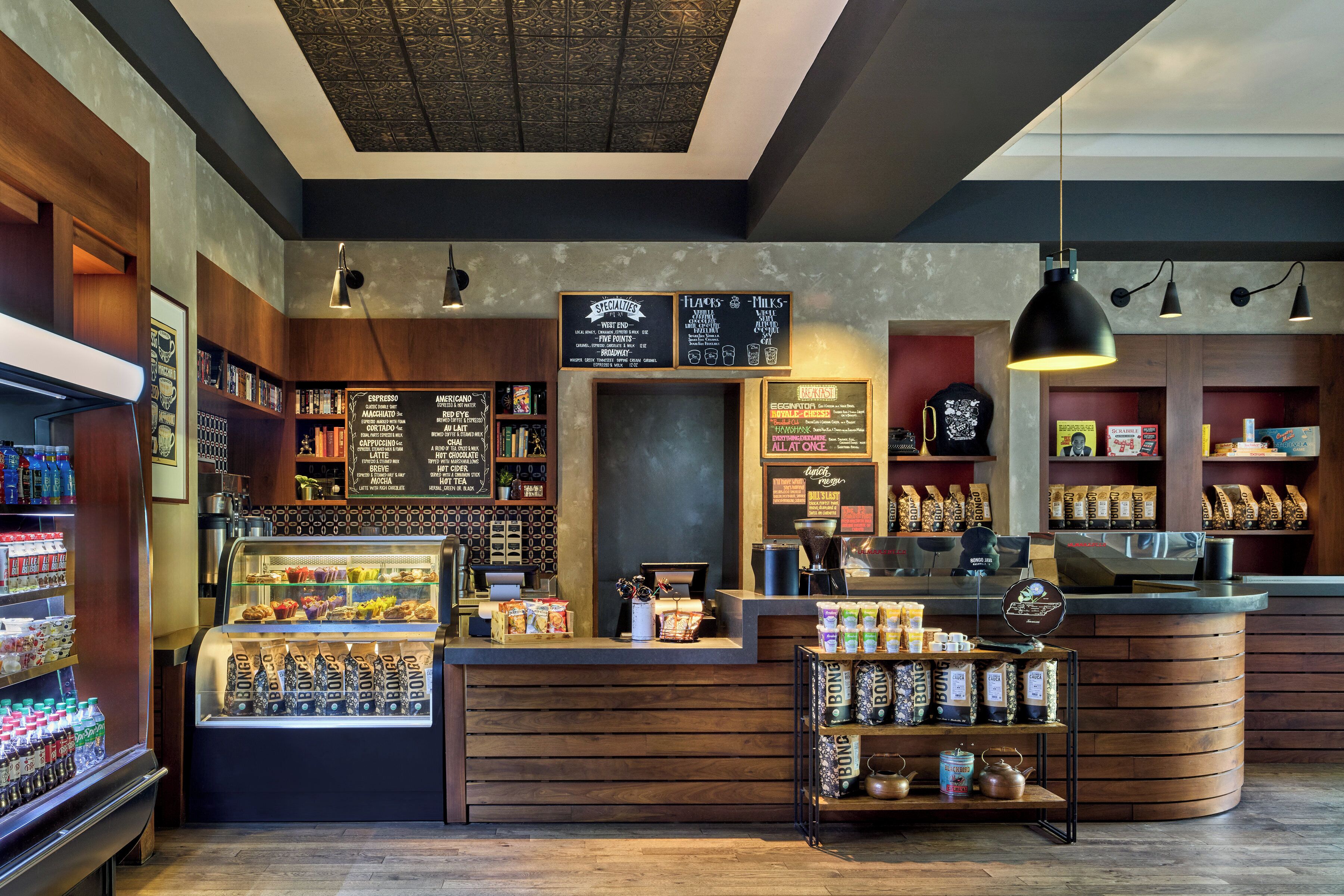 A coffee shop interior with a counter, display cases, and shelves stocked with coffee beans and other items.