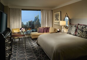 Senger med overmadrass, safe på rommet, skrivebord og blendingsgardiner