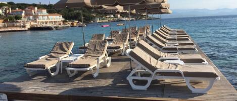 Privat strand, solstolar, parasoller och strandhanddukar