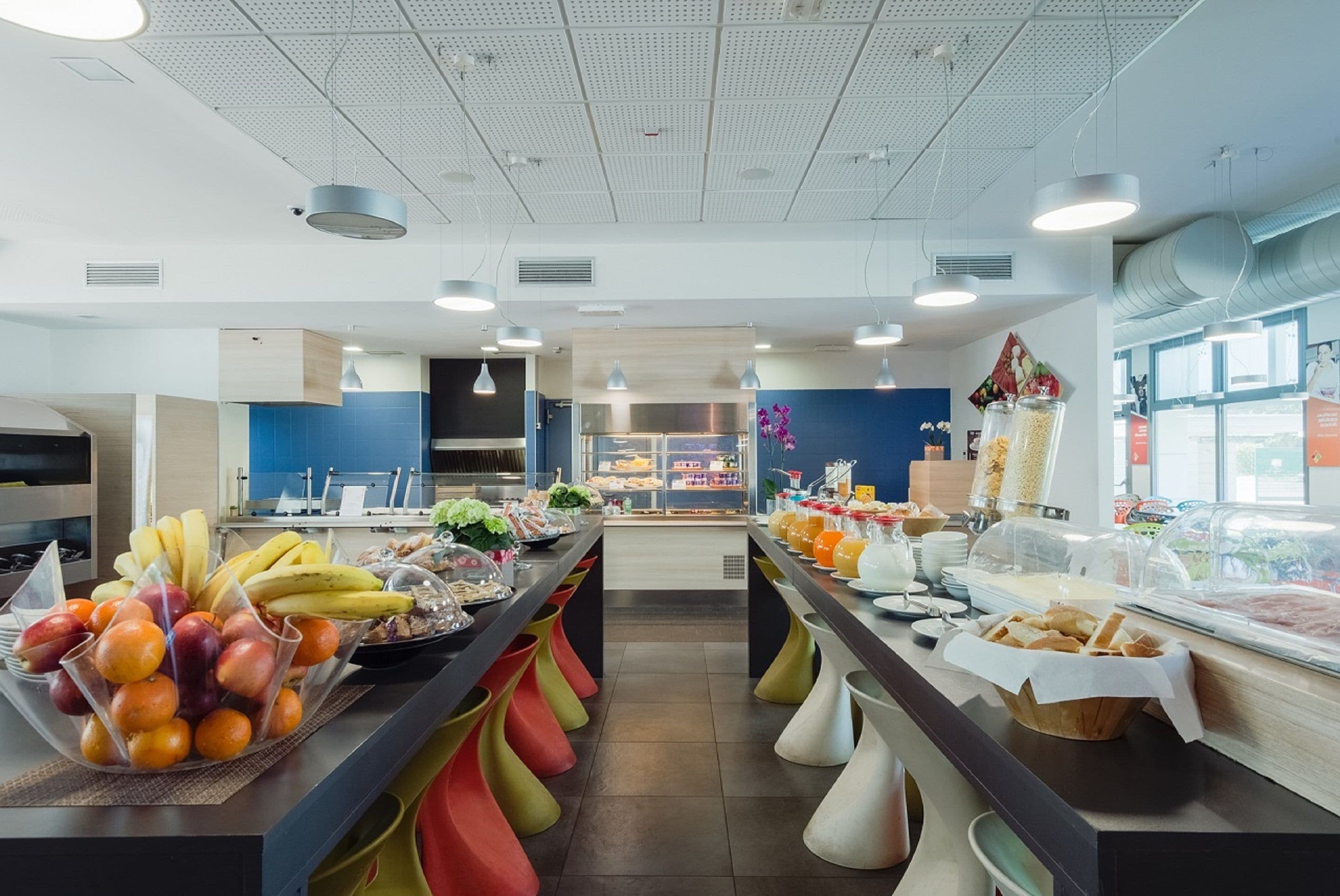 Un área de buffet con diferentes opciones de comida y una cocina al fondo.