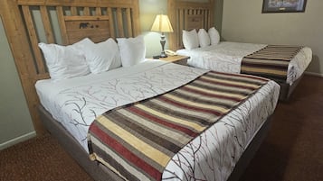 Una cama doble con un edredón a rayas y un cabecero con diseño de madera.