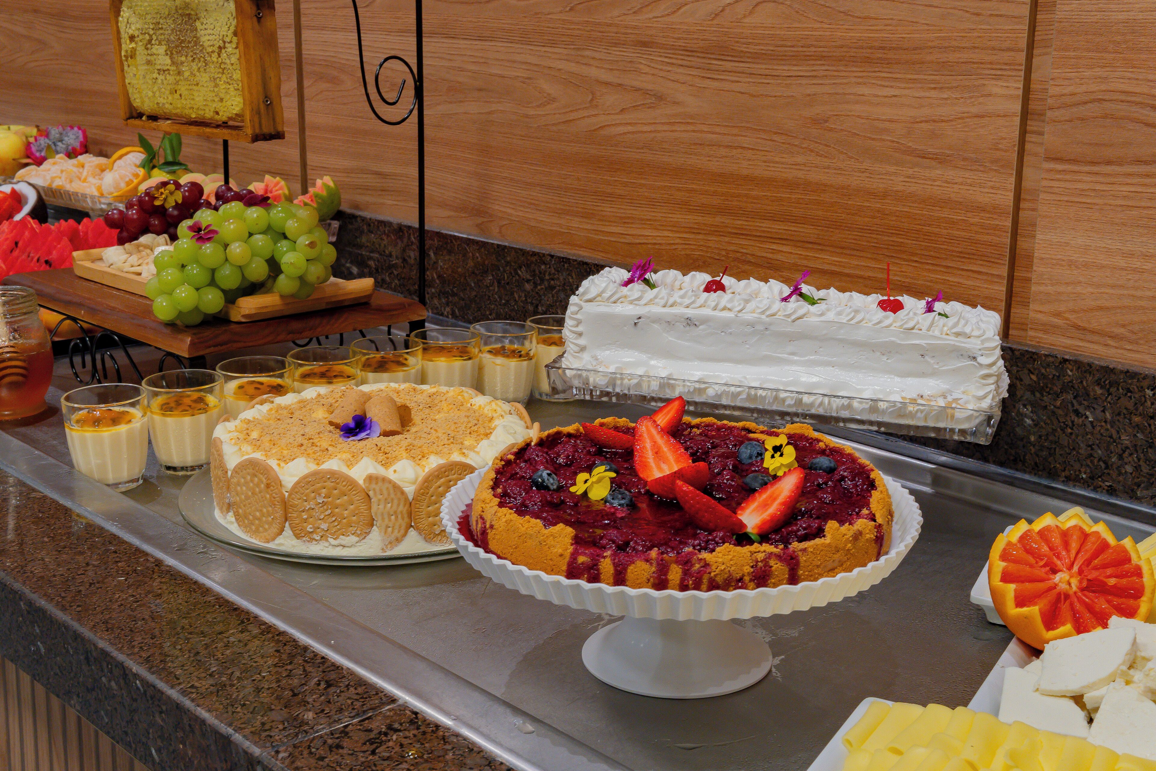 Ein Buffet mit verschiedenen Desserts, darunter Kuchen und Obsttörtchen.