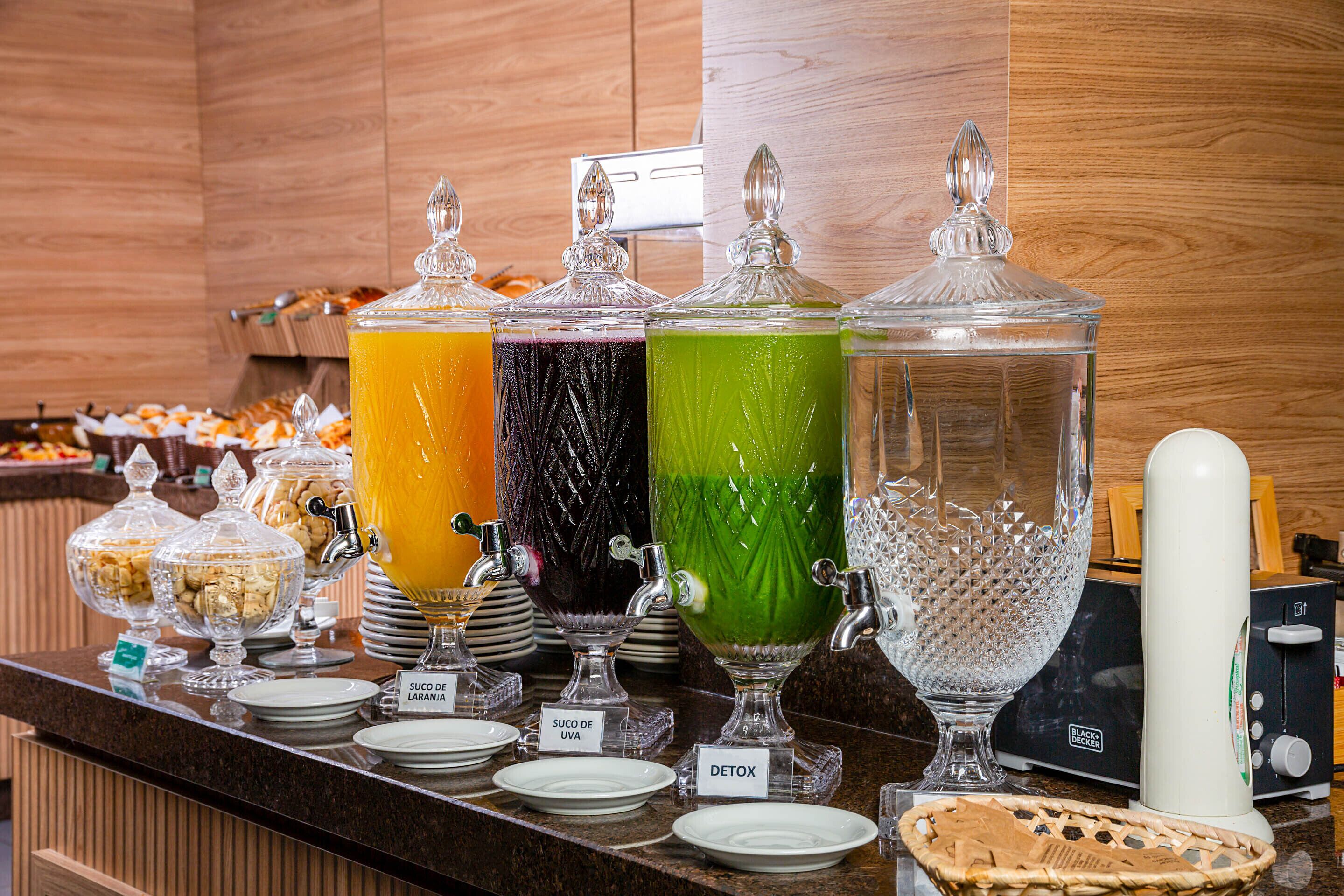A buffet counter with various food items and a juice bar.