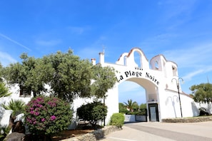 A white building with an arched entrance labeled "La Plage Noire". - La Plage Resort (Sorso)