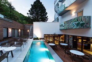 A modern outdoor pool area with seating and a bar. - The Royal Snail (Namur)