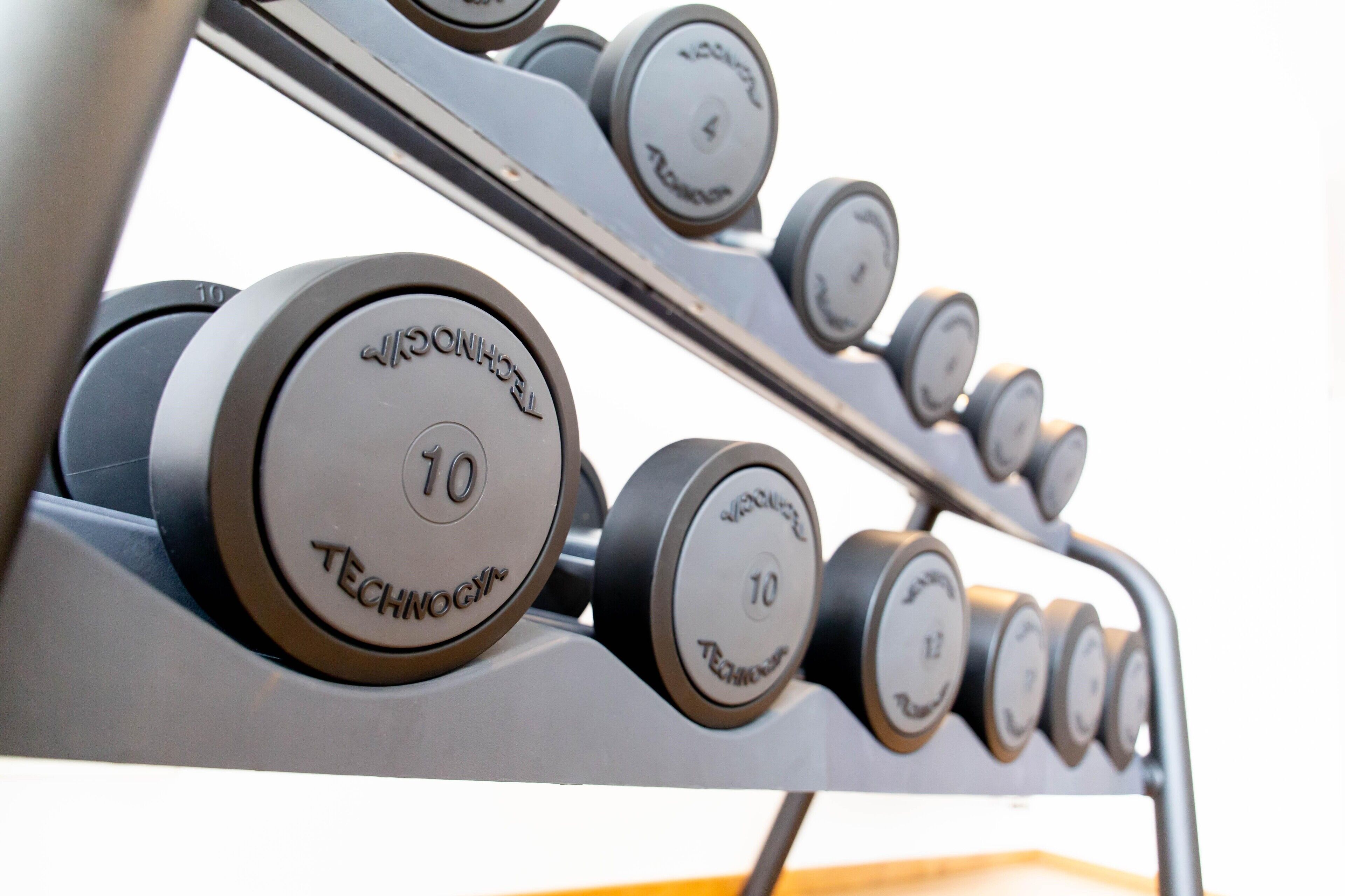 A set of dumbbells with weight markings, indicating a fitness equipment area.