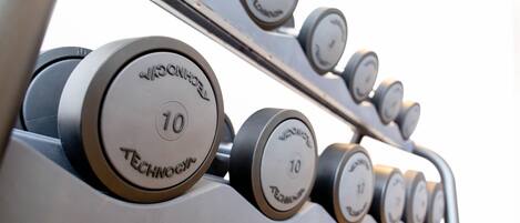 A set of dumbbells with weight markings, indicating a fitness equipment area.