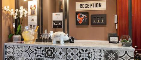 Ett receptionsområde med en kakelbeklädd disk, en skylt med texten ”reception” och en dekoration i form av en gris.