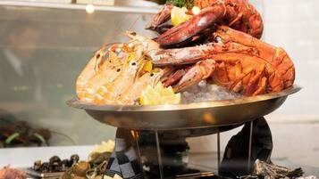 A seafood display with lobsters and oysters on ice, with menus in the background.