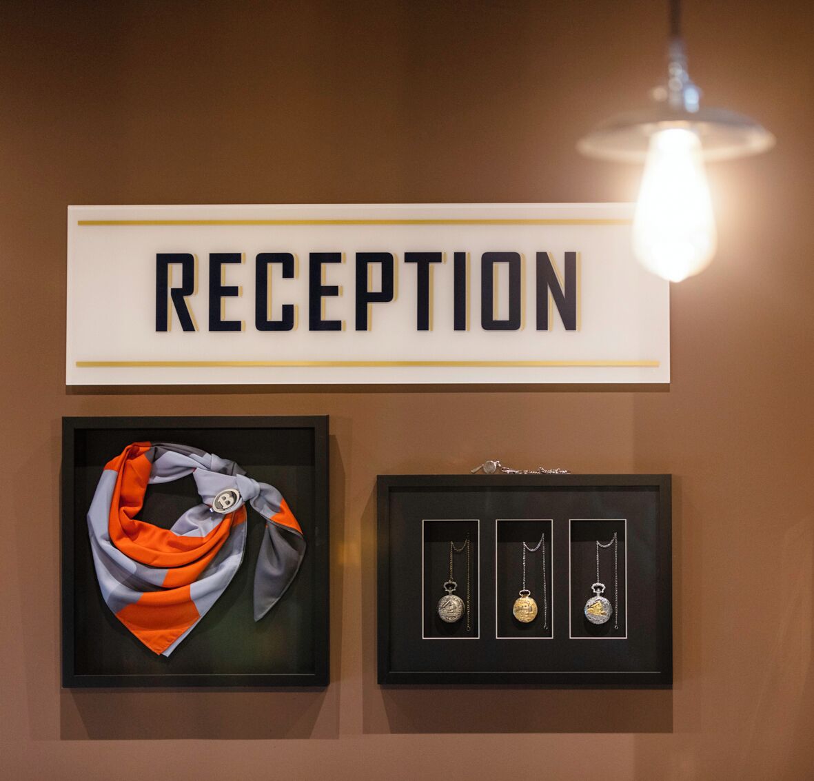 En receptionsskilt, et indrammet sjal og tre indrammede vedhæng.