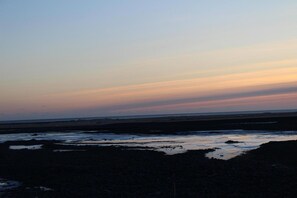A coastal landscape during sunset with a flat horizon and no visible structures. - Welcome Lambafell (Rangárþing eystra)