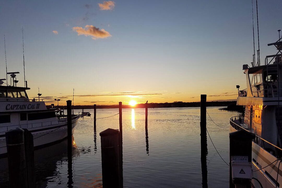A boat docked at a pier during sunset.