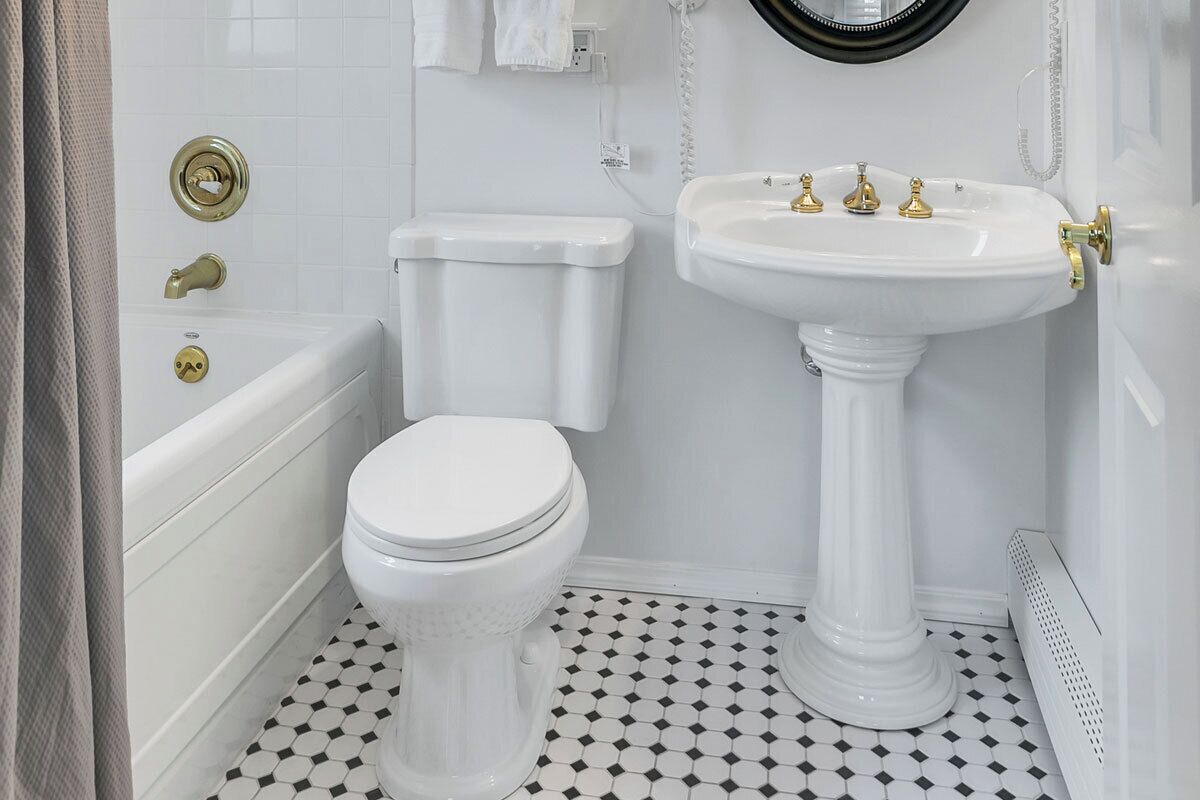 Un bagno con il water bianco, un lavabo su piedistallo e una vasca.