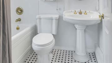 Un bagno con il water bianco, un lavabo su piedistallo e una vasca.