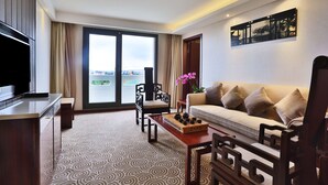 A modern living room with a sofa, coffee table, and TV. - Huatian Chinagora Hotel (Alfortville)