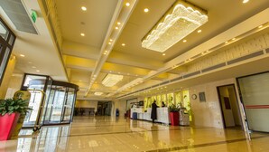 A spacious lobby with a reception desk, potted plants, and a modern chandelier. - Huatian Chinagora Hotel (Alfortville)