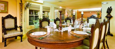 Comedor con una mesa de madera dispuesta para cuatro personas, rodeado de sillas tapizadas.