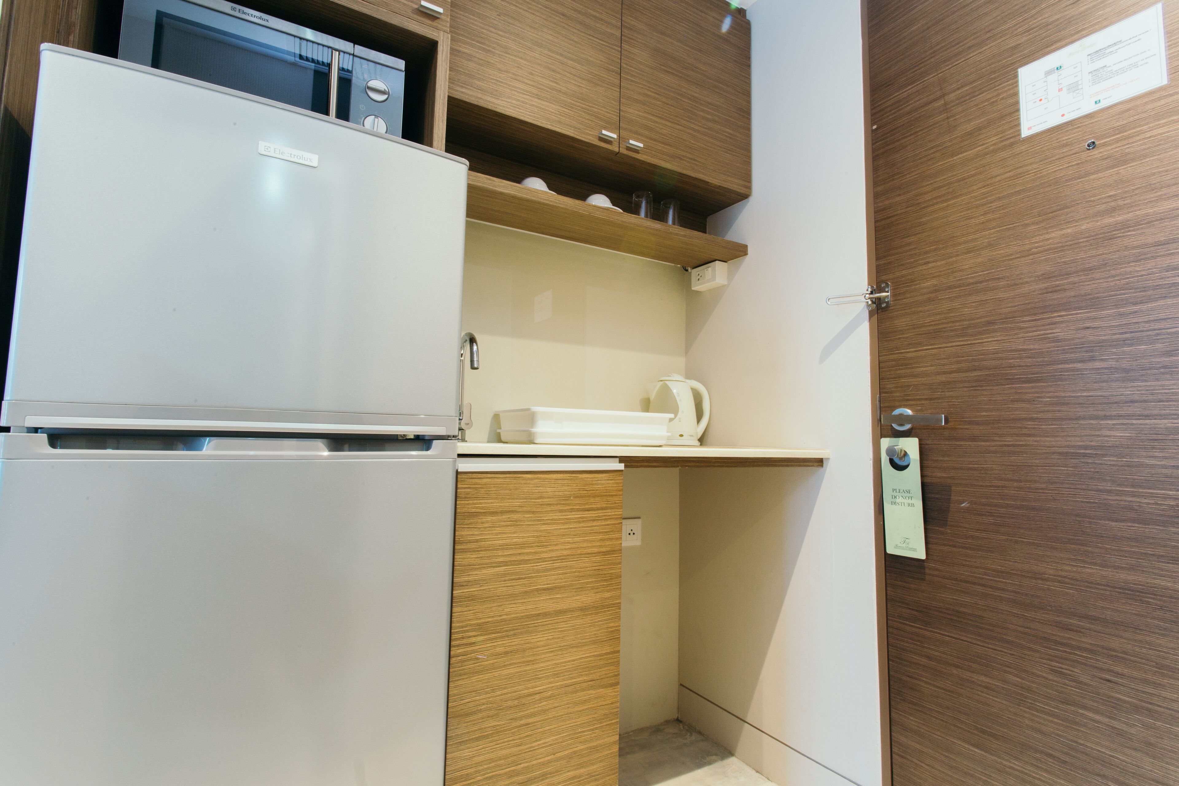 A compact kitchenette with a refrigerator, microwave, and a small countertop.