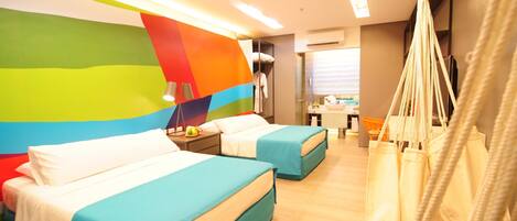 A hotel room with two beds, a colorful wall, a hammock, and a small kitchenette.
