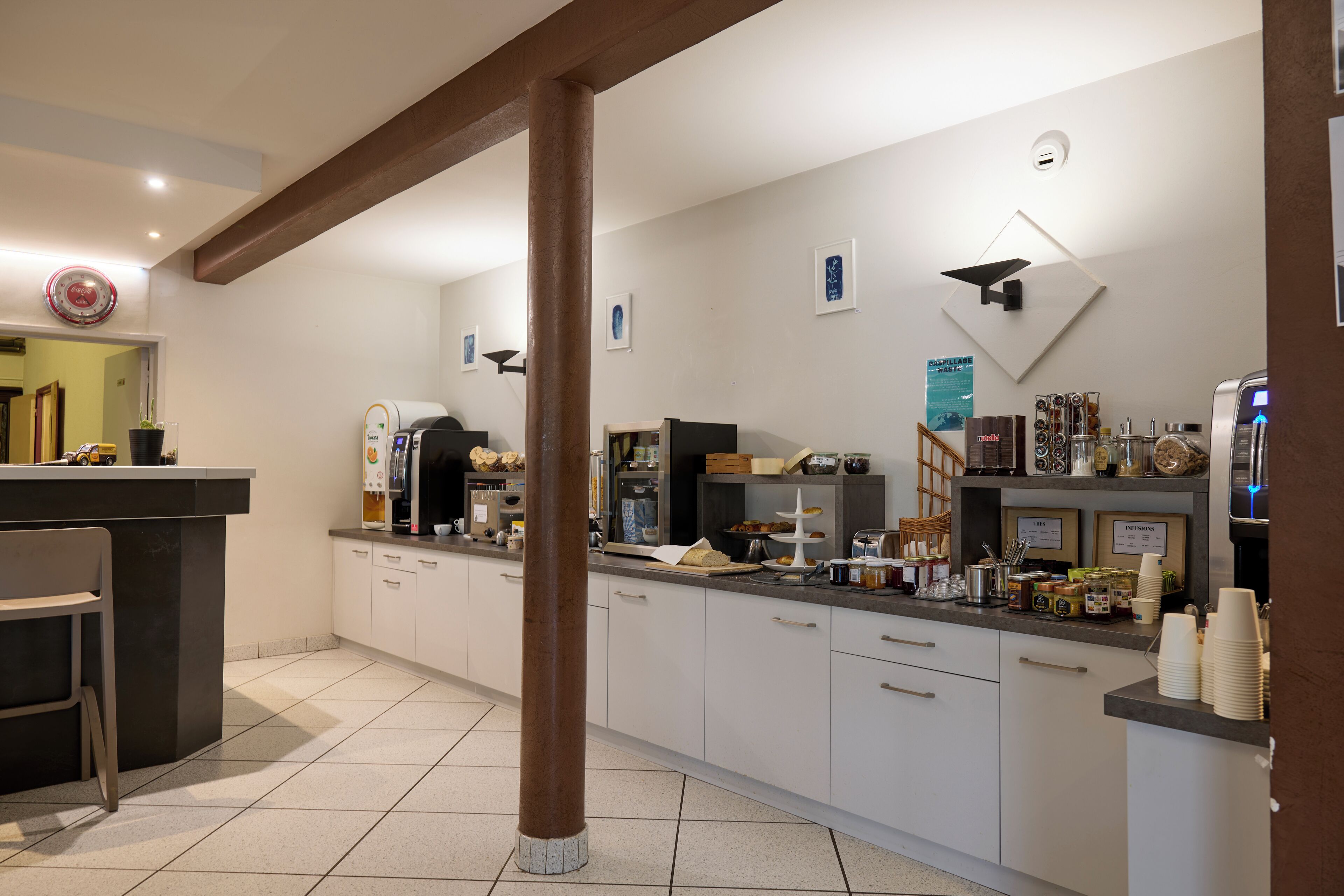 A modern kitchen with white cabinets, a central island, and various appliances.