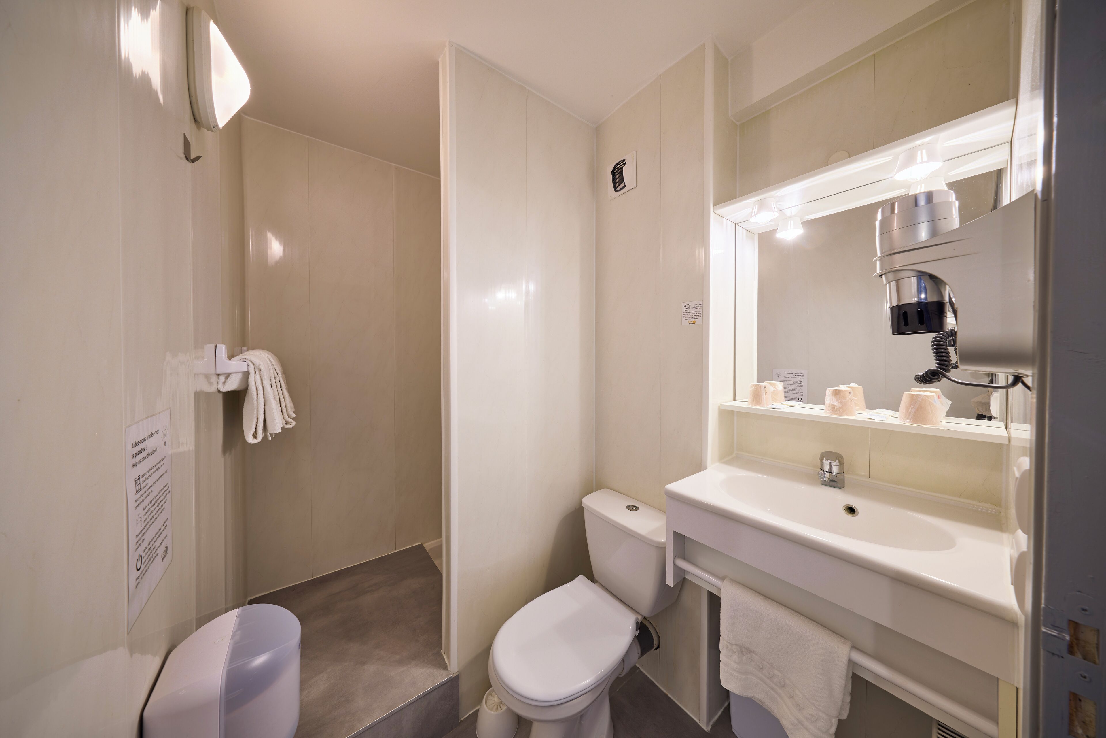 Un baño moderno con inodoro, lavamanos y ducha.