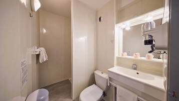 Un baño moderno con inodoro, lavamanos y ducha.