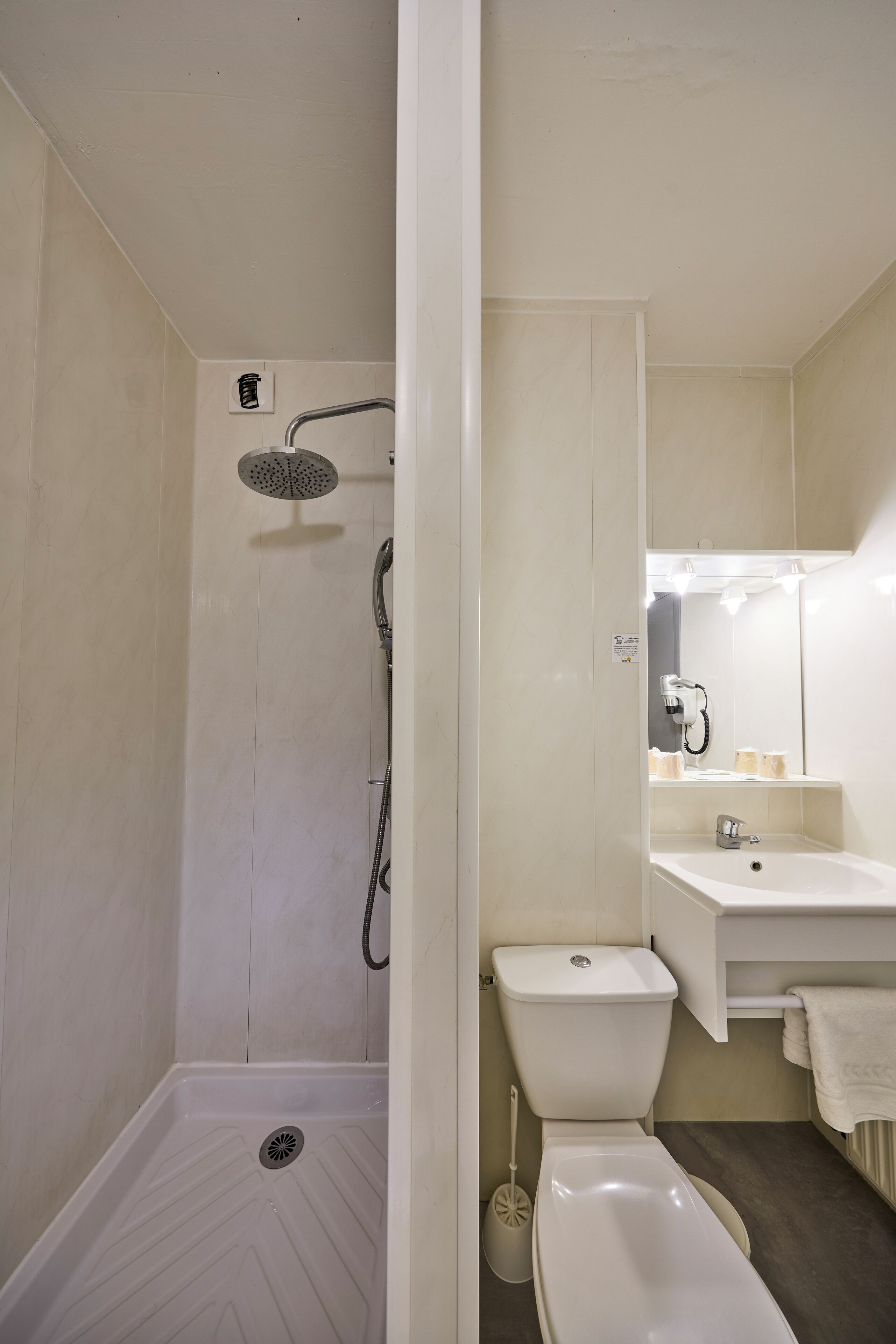 Un baño con ducha, inodoro, lavamanos y espejo.
