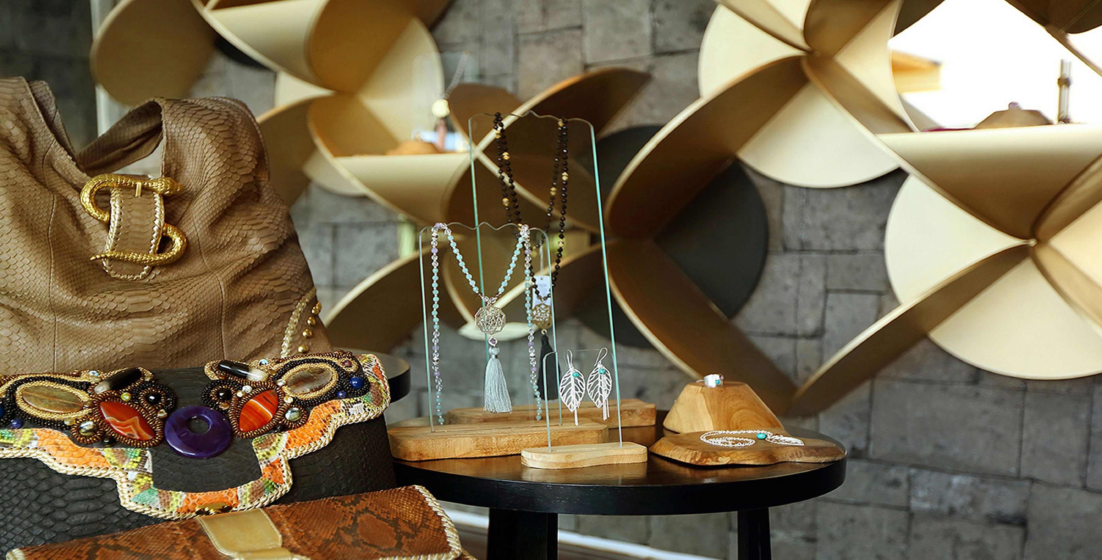 Una exhibición de joyas, incluyendo collares, aretes y un bolso con un cierre dorado.