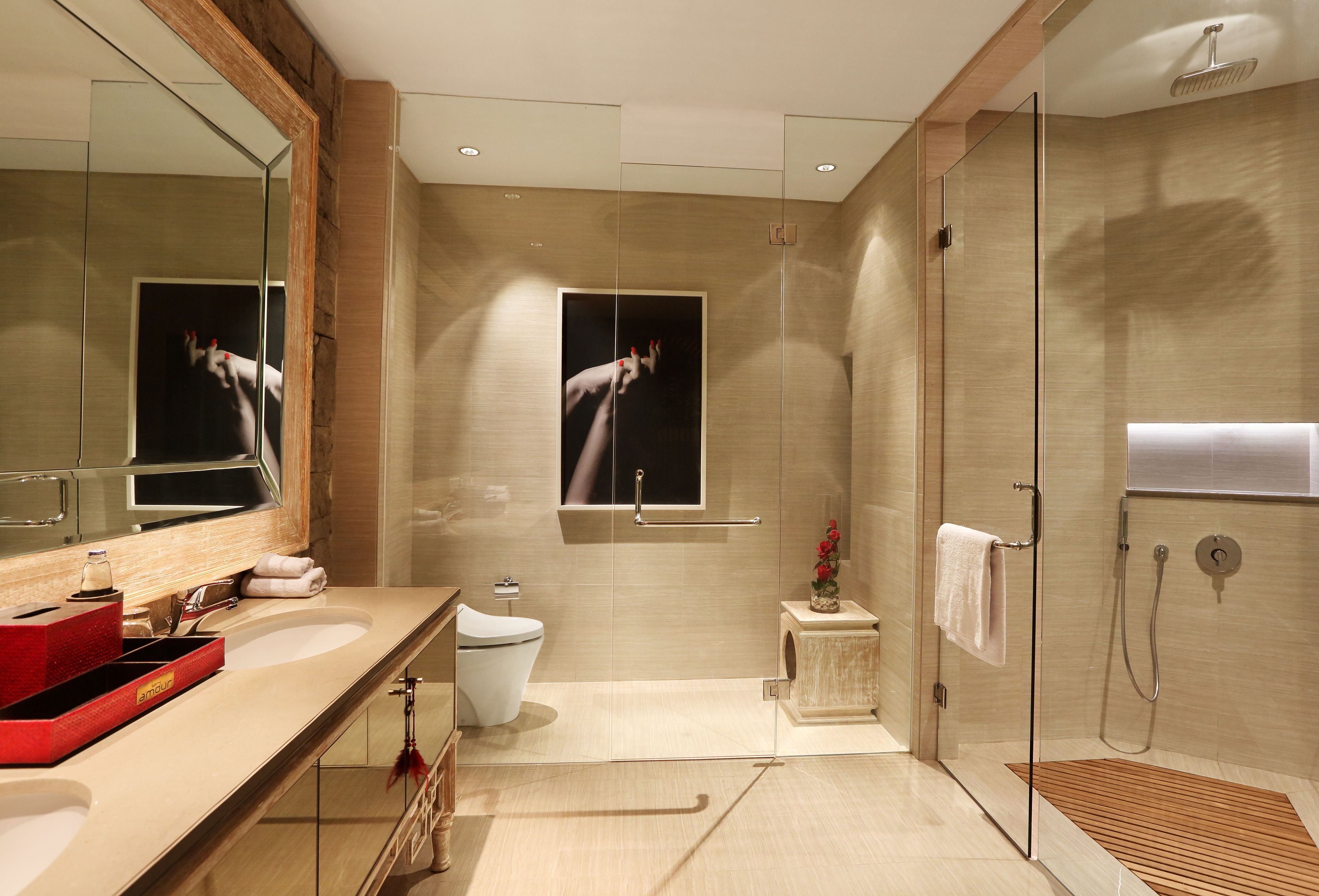 A modern bathroom with a large mirror, a glass shower enclosure, and a wooden vanity.
