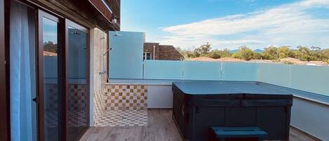 Une terrasse sur le toit avec un plancher en bois, un barbecue intégré et un espace salon.
