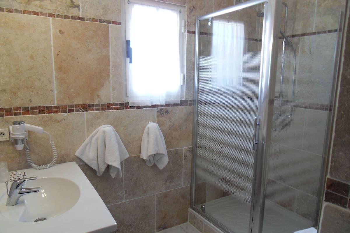 shower, hair dryer, slippers, towels