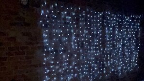 Una piscina con pared de ladrillo e iluminación colgante.