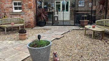 Step into a charming entrance with a welcoming sign, glass doors, and a cozy bench.