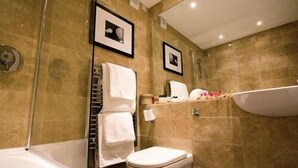 A bathroom with a bathtub, toilet, and a shower area. - Plantation House Hotel (Ivybridge)