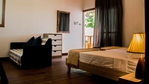 A bedroom with a bed, a sofa, a dresser, and an air conditioning unit. - Gecko Lipe Resort (Koh Lipe)