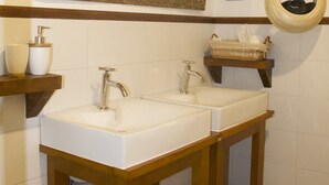 A bathroom with two sinks, wooden vanity, and a large mirror.