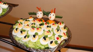 A platter of deviled eggs with decorative elements on a silver tray.
