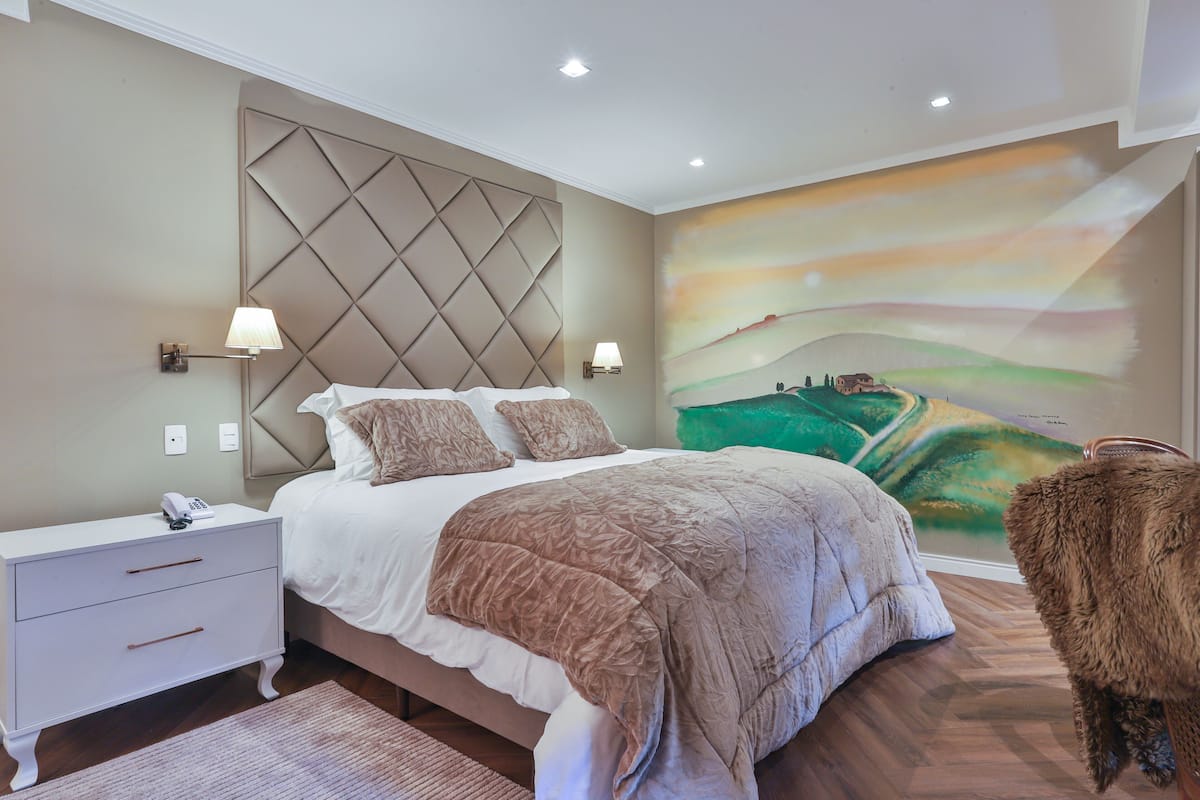 Un dormitorio con cama, mesita de noche y decoración en la pared.